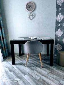 Un escritorio con una silla y un reloj en la pared. en Here comes the sun, en Batumi 19 fotos más