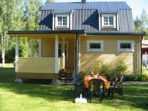 a small yellow house with a table and chairs at Stuga på Brattmon in Sysslebäck