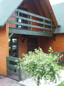 een huis met een balkon en een bos ervoor bij Ośrodek Wypoczynkowy OAZA in Wągrowiec