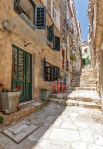 eine Gasse in einer Altstadt mit grüner Tür in der Unterkunft Apartment Potkova in Dubrovnik
