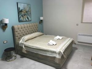 um quarto com uma cama grande e toalhas em Aenaon Rooms em Nafplio