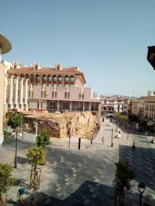 una plaza de la ciudad con un gran edificio en el fondo en Vivienda Turística Templo Romano en Córdoba