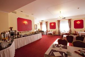 a restaurant with tables and chairs in a room at Hotel Savoy in České Budějovice