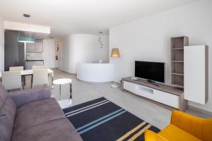 a living room with a couch and a tv at Victory Village Sea Views in Quinta do Lago