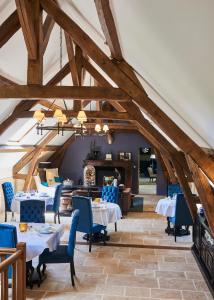 une salle à manger avec des tables et des chaises bleues dans l'établissement Moulin Royale, à Saint-Etienne-Roilaye