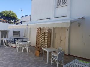 un patio con mesas y sillas y un edificio en Guest House - La Sirena Salentina, en Patù