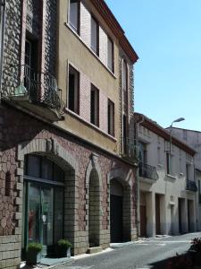 a brick building with windows and a door on a street at Maison Baxter in Prats-de-Mollo-la-Preste