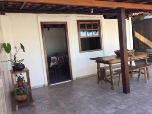 a patio with a wooden table and a window at Casa Recanto dos Encantos! in Tiradentes