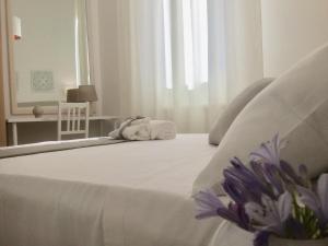uma cama branca com toalhas por cima em Il ponte sul Salento em Trepuzzi