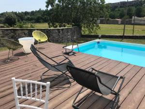 eine Terrasse mit 2 Stühlen und einem Pool in der Unterkunft B&b Il Cortile in Biella
