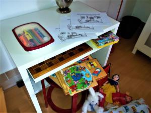 Un escritorio blanco con una mesa con un juguete que se puede presentar a la Agencia en Haus Taekema Appartments en Glanegg