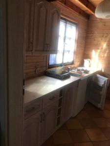 een keuken met een aanrecht, een wastafel en een raam bij Ośrodek Wypoczynkowy OAZA in Wągrowiec