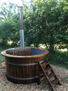 d'un bain à remous en bois avec un poteau. dans l'établissement Riverwood Farm Glamping Safari Tent, à Talaton