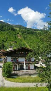 a building with a hill in the background at DEP GÄSTEHAUS Residenz in Neukirchen am Großvenediger