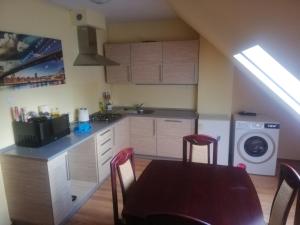 a kitchen with a table and chairs and a washing machine at Boczna 9 Apartament in Karpacz