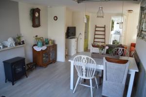 een woonkamer met een tafel en stoelen en een fornuis bij Bijzonder Bakkum in Castricum