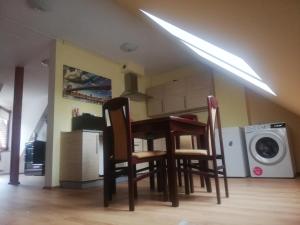 a table and chairs in a kitchen with a washing machine at Boczna 9 Apartament in Karpacz +8 photos