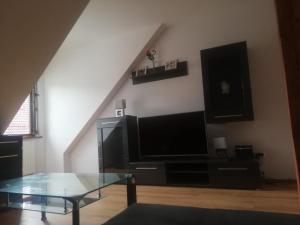 a living room with a tv and a glass table at Boczna 9 Apartament in Karpacz