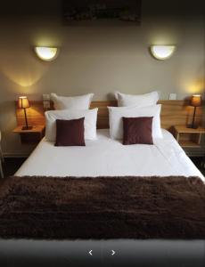 uma grande cama branca com 2 almofadas e 2 candeeiros em Hotel les Glycines em Prades