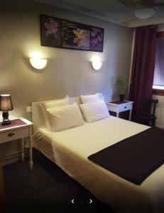 um quarto de hotel com uma cama grande e uma mesa em Hotel les Glycines em Prades