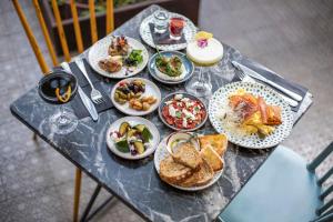 a table topped with plates of food on top of a wooden table at Fabric Hotel - an Atlas Boutique Hotel in Tel Aviv