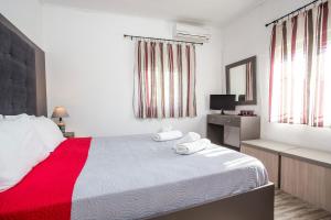 een slaapkamer met een groot bed en een rode deken bij Filerimos House in Ialyssos
