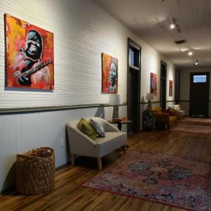 - un salon avec un canapé et un tableau mural dans l'établissement HOSTEL Auberge Clarksdale, à Clarksdale