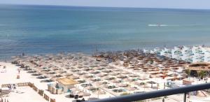 eine Luftansicht auf einen Strand mit Sonnenschirmen und dem Meer in der Unterkunft Bluemarina Apartamente in Mamaia