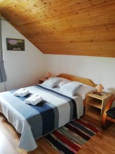 a bedroom with a bed and a wooden ceiling at House Viktoria in Seliste Dreznicko