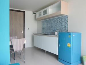 a kitchen with a blue refrigerator in a room at R-Con Blue Ocean in Pattaya