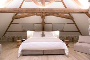 - une chambre avec un lit blanc et un canapé dans l'établissement Couvent de la Salette & Spa, à Millau