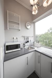 a white kitchen with a microwave and a sink at Boleslav Home in Sucha Beskidzka