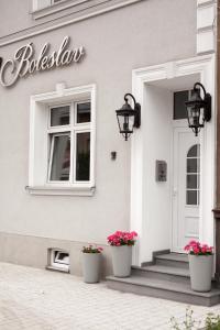 a white building with two potted flowers on the doorstep at Boleslav Home in Sucha Beskidzka