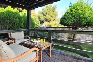 a porch with a couch and a table on a deck at Bikta Banof in Rosh Pinna