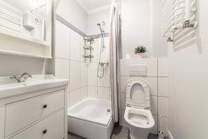 a white bathroom with a toilet and a sink at Boleslav Home in Sucha Beskidzka +13 photos