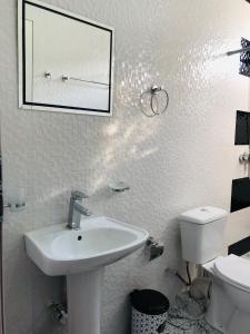 Guesthouse Family في باتومي: حمام أبيض مع حوض ومرحاض