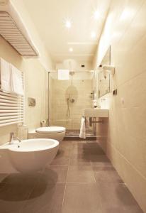 uma casa de banho com 2 lavatórios, um WC e um chuveiro em La Villa em Siena