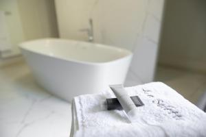 a white bathroom with a sink and a towel at Couvent de la Salette & Spa in Millau