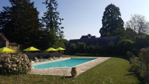 - une piscine avec des chaises et des parasols dans la cour dans l'établissement Château de Montpatey, à Couches