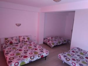 twee bedden in een kamer met roze muren bij Thai House in Costinesti