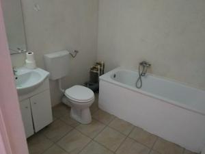 een badkamer met een toilet, een bad en een wastafel bij Thai House in Costinesti