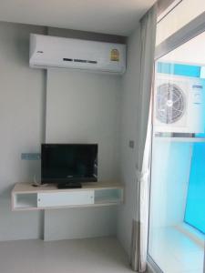 a living room with a tv and a fan at R-Con Blue Ocean in Pattaya