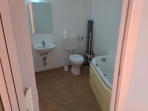 een badkamer met een toilet, een wastafel en een bad bij Thai House in Costinesti