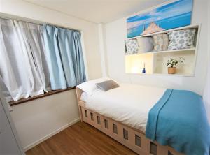 a small bedroom with a bed and a window at SHINJUKU 5-ROOM Family house in Tokyo