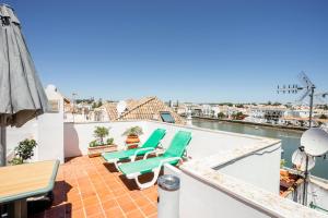 a balcony with chairs and a view of the water at Residencial Mares in Tavira