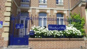 ceglany budynek z niebieską bramą i białymi kwiatami w obiekcie AU 52 w mieście Beauval