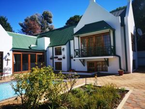 a large white house with a swimming pool at The Gables-Clarens in Clarens