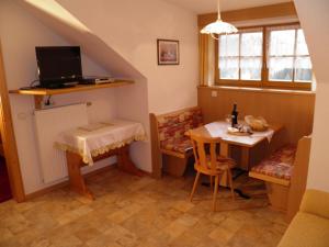 un petit salon avec une table et une télévision dans l'établissement Flatscherhof, à San Lorenzo di Sebato