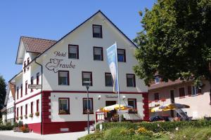 een groot wit gebouw met een bord ervoor bij Hotel Garni Traube in Friedrichshafen