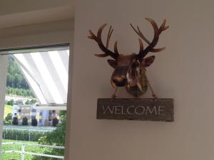a sign with a deer head hanging on a wall at Sunny Apartment in Innsbruck